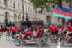 A quadcycle passes Downing street amongst the Cyclists on Whitehall.
